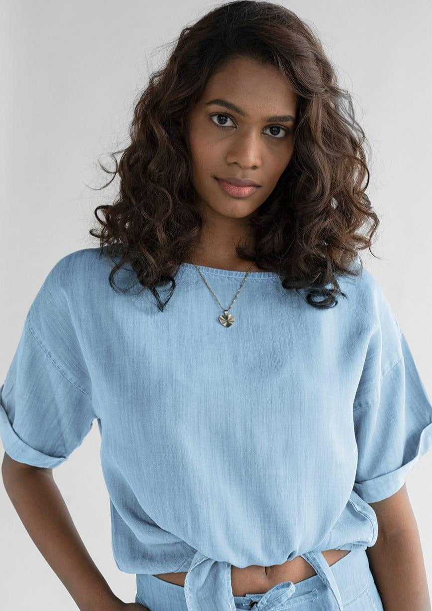 Reistor Twist and Sway Top in Blue, women's blue crop top featuring a tie-fitted waist, loose cap sleeves, and breathable sustainable fabric for everyday style.