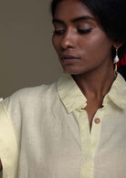 collared yellow shirt with brown buttons. Reistor