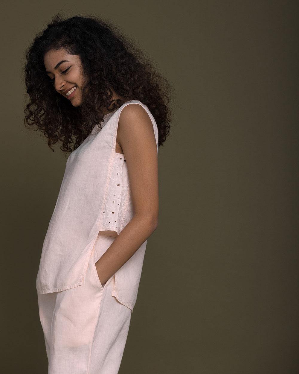 pastel pink sleeveless top with embroidered detailing on the sides. Reistor