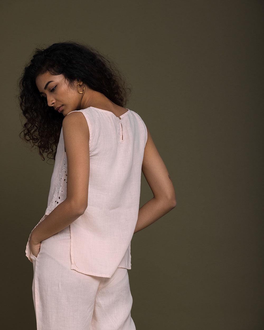 pastel pink sleeveless top with embroidered detailing on the sides. Reistor