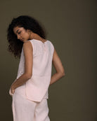 pastel pink sleeveless top with embroidered detailing on the sides. Reistor