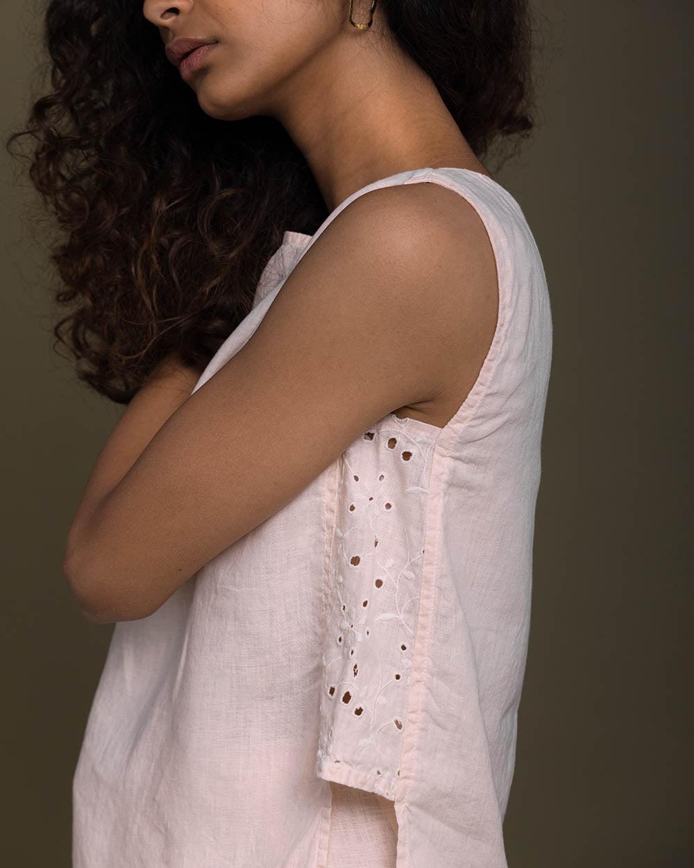 pastel pink sleeveless top with embroidered detailing on the sides. Reistor