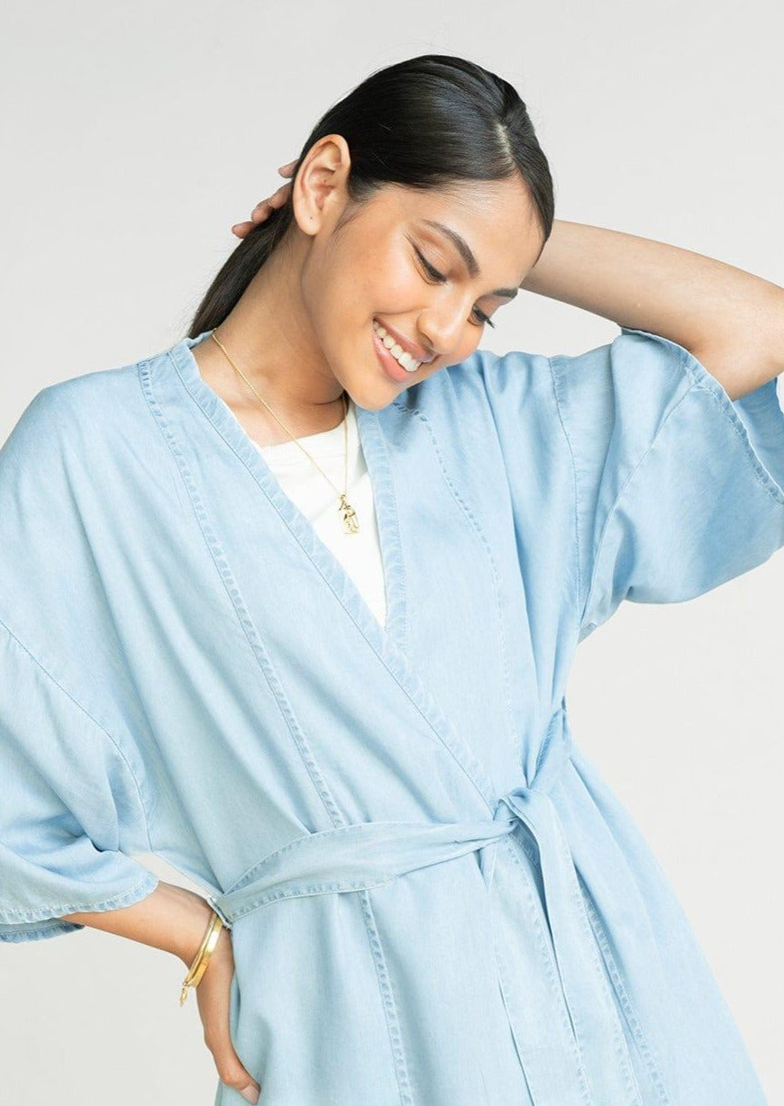 Close-up of the Reistor Wrapped in Happiness Overlay in Ocean Blue with a flattering V-neckline, kimono sleeves and breathable lightweight fabric.